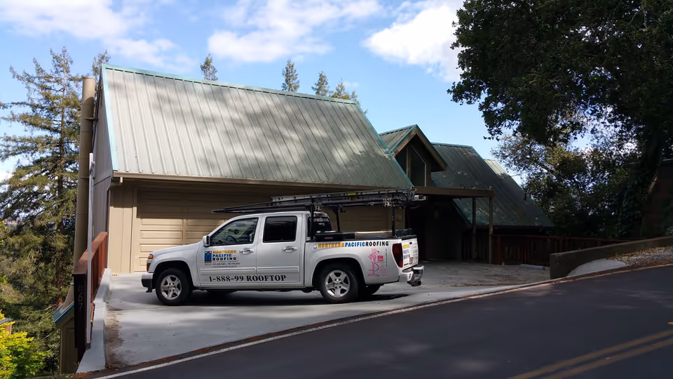 Standing-seam metal roof installation on a hillside home — residential roofing by Northern Pacific Roofing