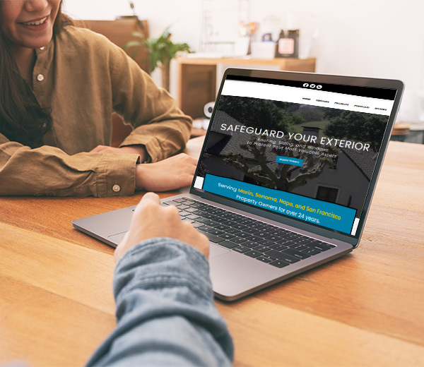 2 people looking at the Northern Pacific Roofing website on a laptop